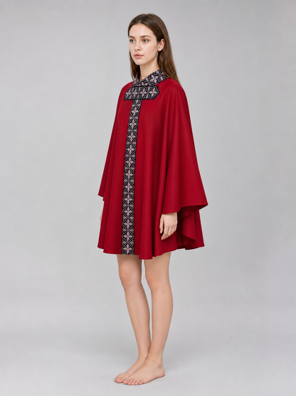 The cape is red with black decorative elements. It has a loose cloak-style silhouette, wide sleeves, and a collar with black patterned detailing. The front features a vertical decorative stripe down the center and a horizontal stripe across