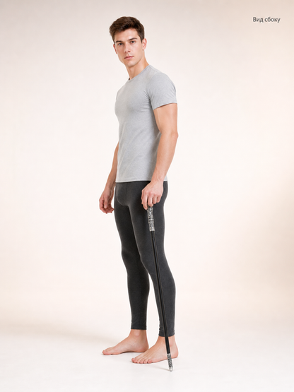 Side view of a man in a gray shirt holding the black cane beside his leg against a light studio background