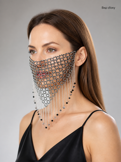 Side view of a black and silver chain mesh mask on a model, showing its layered chains and pointed lower edge