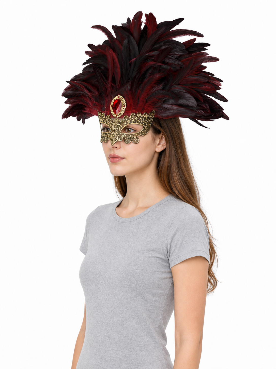 Three-quarter view of a model wearing a burgundy and black feathered mask headpiece with gold filigree and a red oval jewel