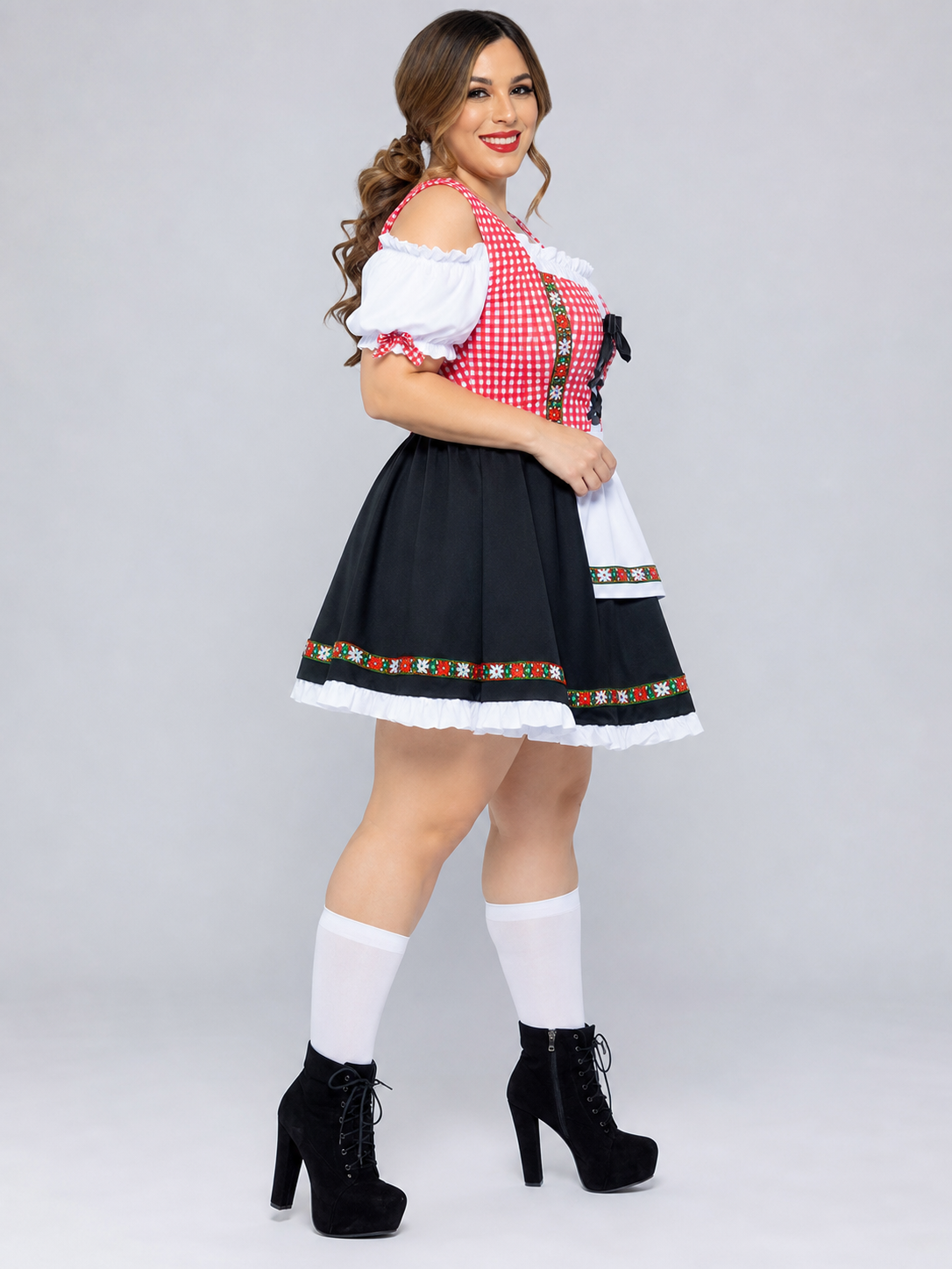 Historical national costume presented as a dress-like outfit with a decorative apron and distinctive details. The design combines white, red, and black colors: the top features a red-and-white checkered pattern, while the lower part is desi