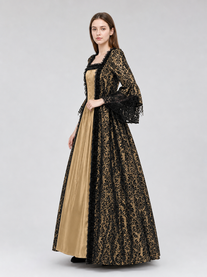 The dress is designed in a historical style with theatrical and decorative details. A golden-beige center is paired with black outer panels and damask-patterned trim, creating a striking contrast. The fitted bodice is decorated with visible