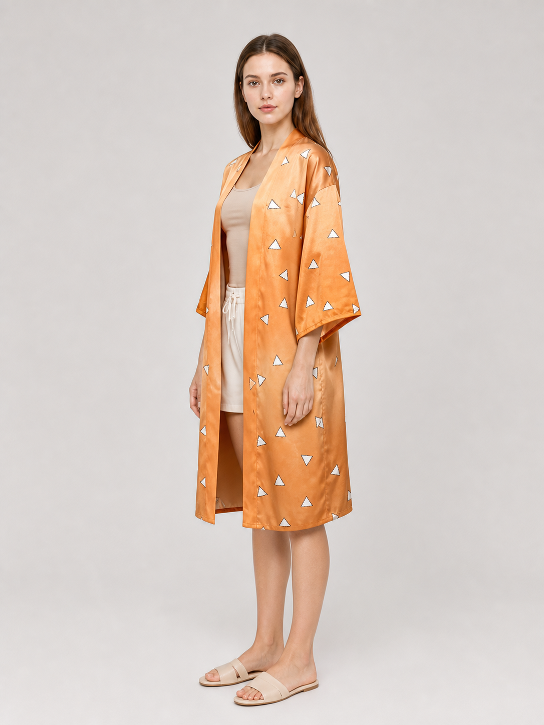 Side view of an orange patterned robe on a model, showing the open front, wide sleeve, and knee-length cut