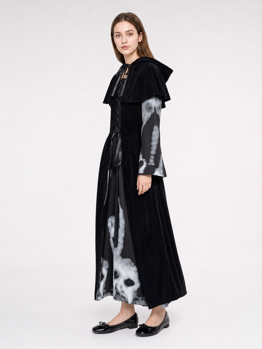 The black witch costume is designed as a long dress with a short shoulder cape. The design features a Halloween theme and is suitable for stage performances, festive events, and themed costumes. The front is decorated with crisscross lacing