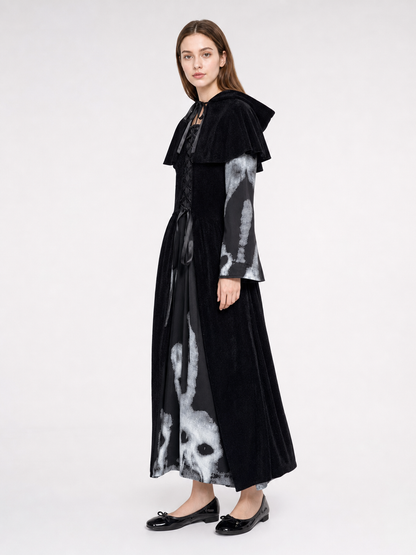 The black witch costume is designed as a long dress with a short shoulder cape. The design features a Halloween theme and is suitable for stage performances, festive events, and themed costumes. The front is decorated with crisscross lacing