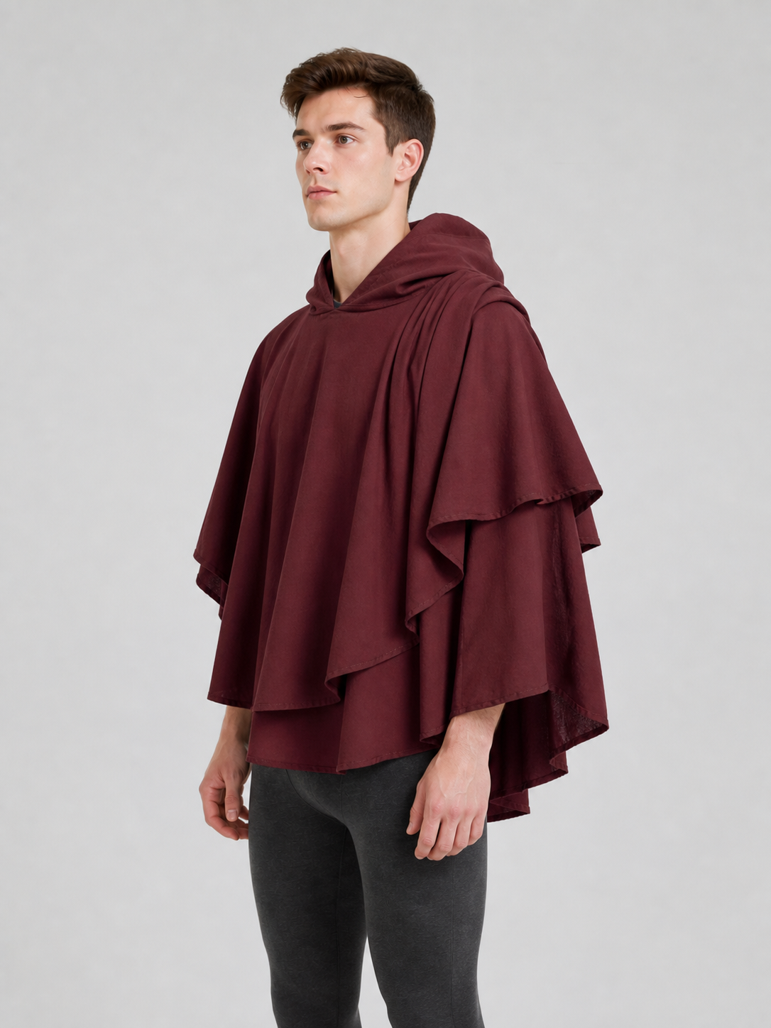 Three-quarter view of the dark red cloak on a man, showing the layered panels and wide drape