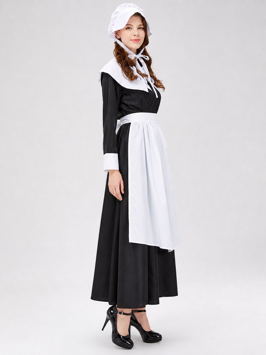 The uniform costume is designed in a black-and-white color scheme and combines elements of a classic maid outfit with a stage costume format. The model creates a complete look with a black top and skirt, long sleeves, white cuffs, a wide wh