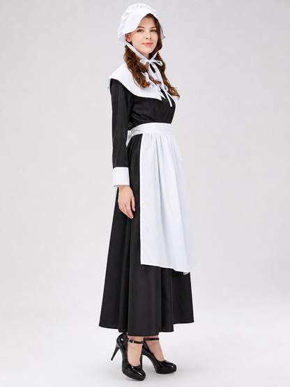 The uniform costume is designed in a black-and-white color scheme and combines elements of a classic maid outfit with a stage costume format. The model creates a complete look with a black top and skirt, long sleeves, white cuffs, a wide wh