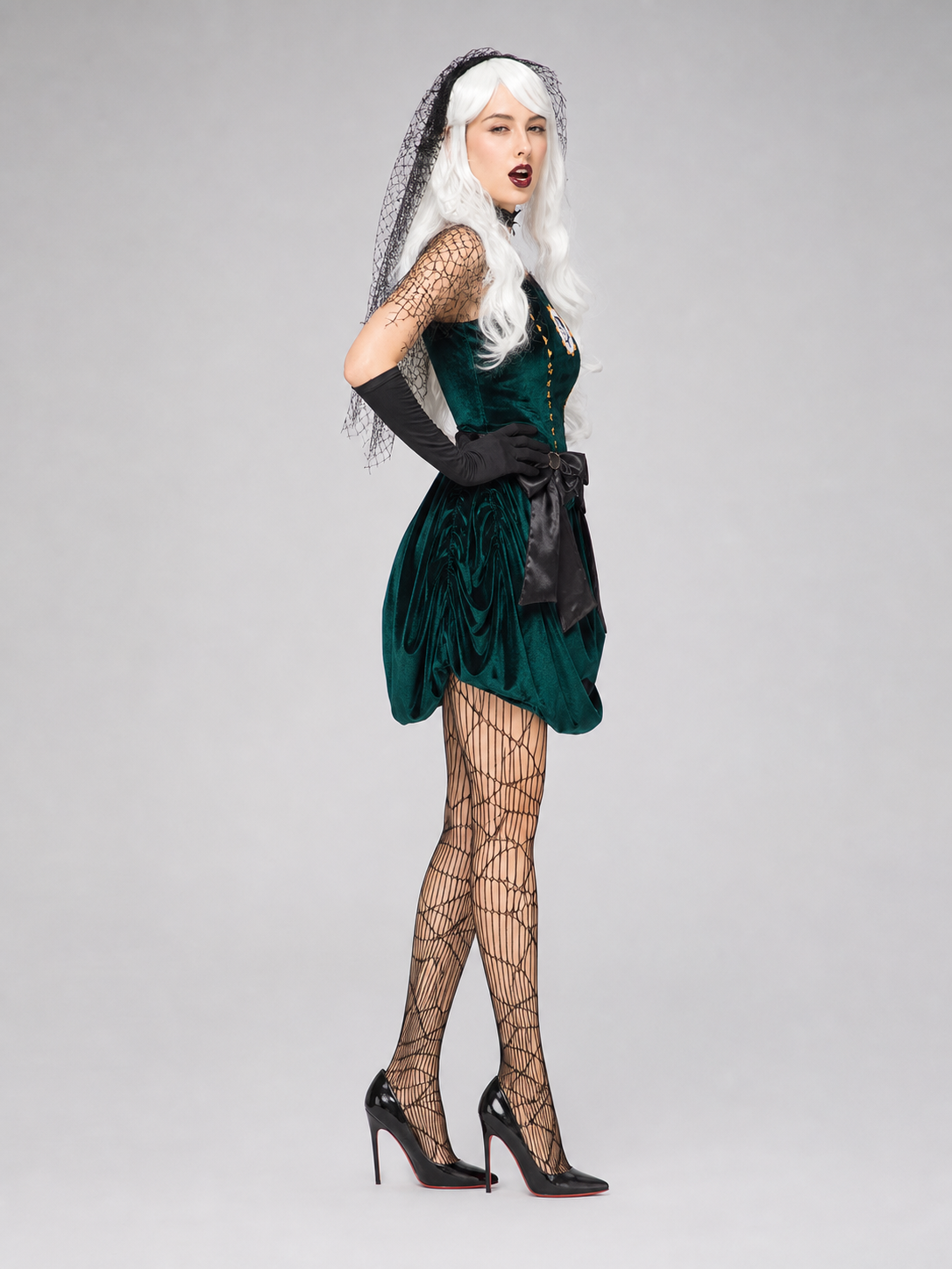 The gothic stage look is designed in deep green with a white pattern and black details. The main piece is a sleeveless dress with a fitted bodice and a short, full skirt silhouette. A circular design featuring a character profile is placed 