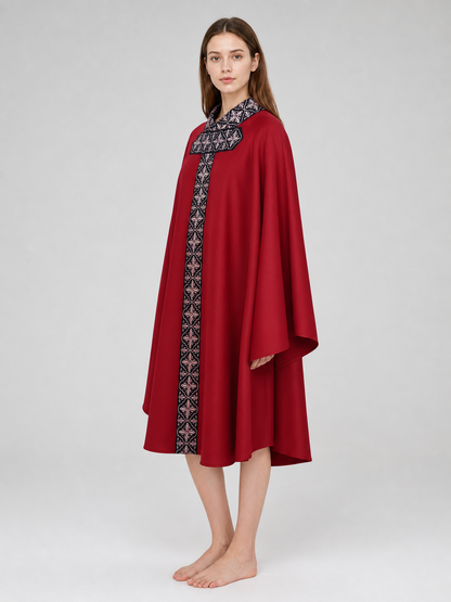 The cape is red with black decorative elements. It has a loose cloak-style silhouette, wide sleeves, and a collar with black patterned detailing. The front features a vertical decorative stripe down the center and a horizontal stripe across