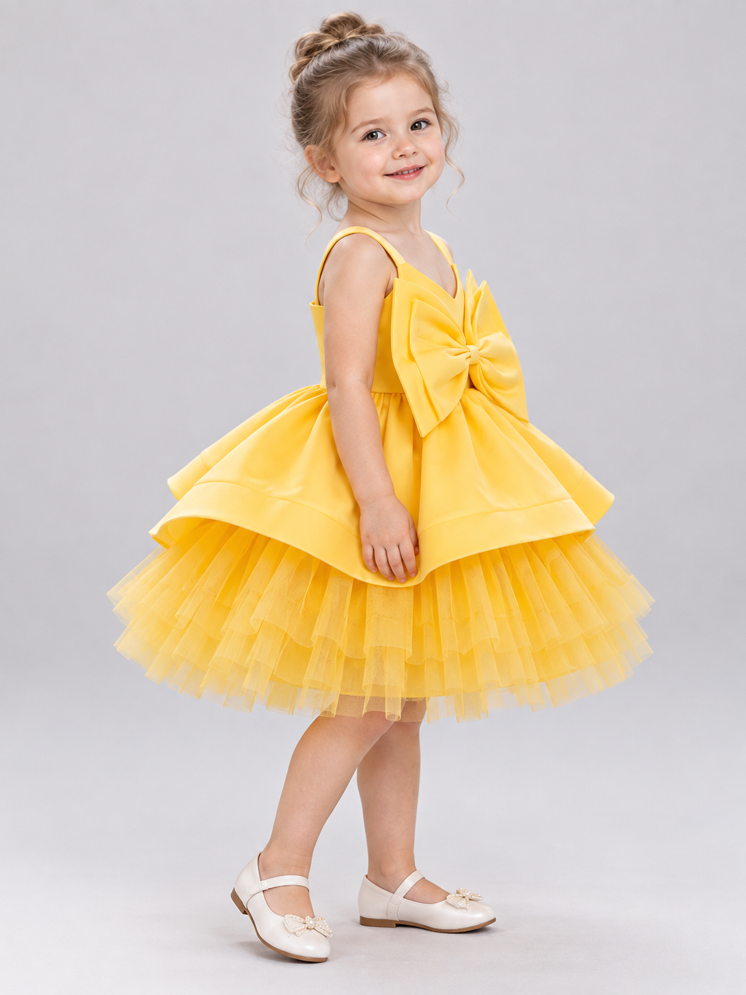 Yellow dress with a bow and a multi-layer tulle skirt