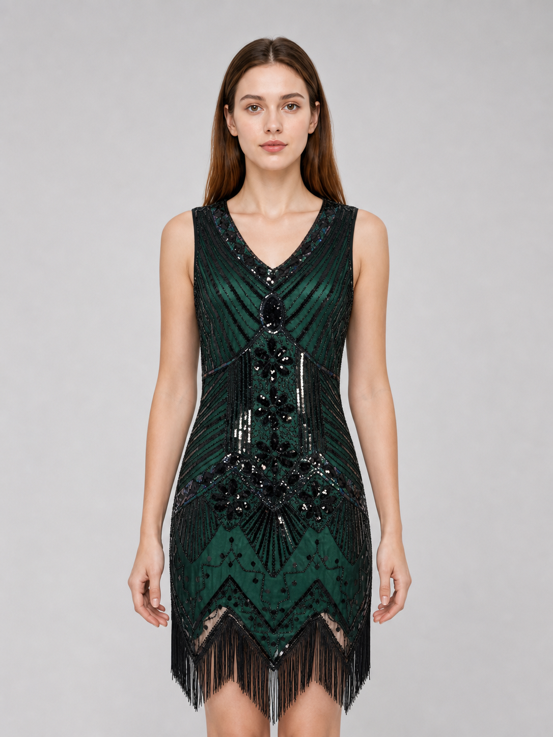 The flapper dress is designed in the Art Deco aesthetic and conveys the signature look of the Gatsby era. The sleeveless design features a V-neckline and a straight silhouette. A geometric and fan-shaped pattern covers the entire surface, c