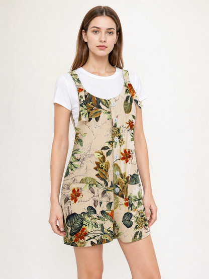 Front view of a beige floral romper over a white T-shirt, showing shoulder straps, front buttons, and short legs