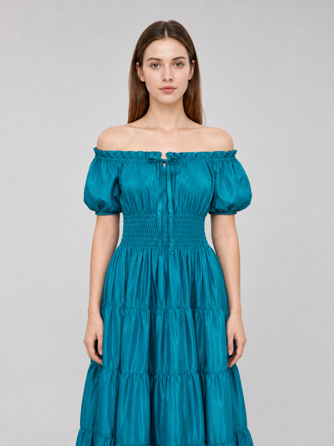 Close front view of a teal satin-look maxi dress on a model, highlighting the ruffled off-shoulder neckline, puff sleeves, and smocked bodice