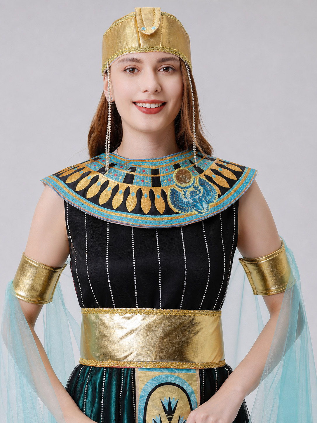 Cleopatra costume designed in an Egyptian-inspired style and decorated in a combination of black, gold, light blue, and blue-green colors. The outfit is centered around a black dress with a skirt and fitted upper section. Vertical sequin st