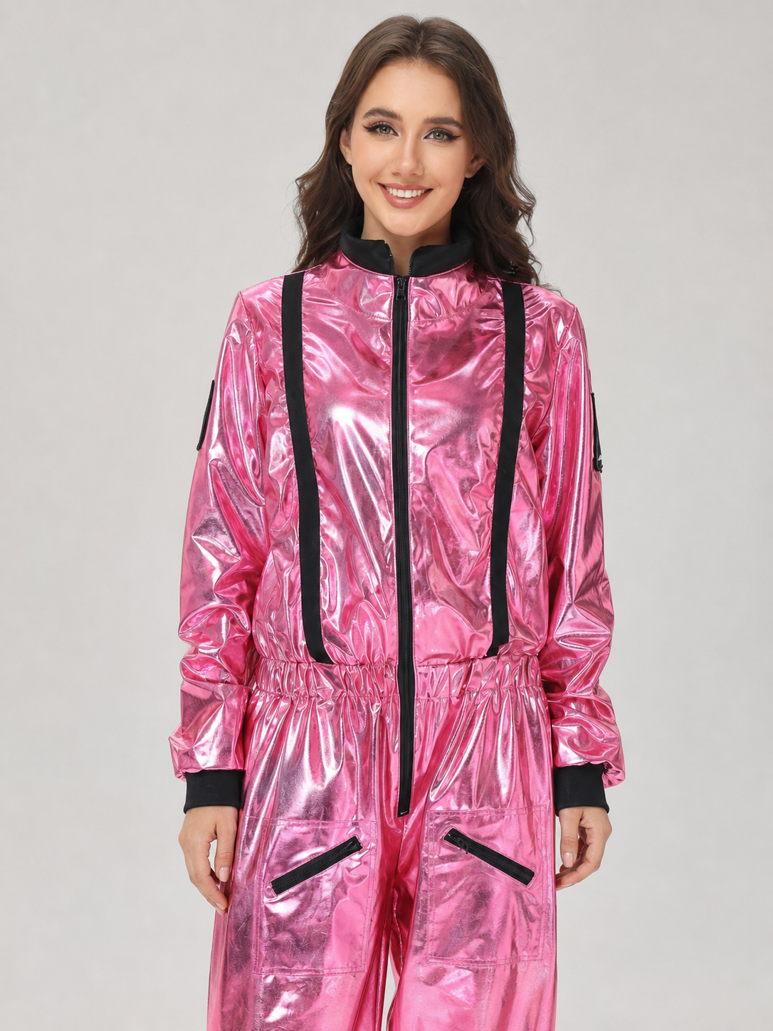 The pink NASA astronaut costume is designed as a one-piece jumpsuit with long sleeves, a stand-up collar, and a central zip closure. The model is pink with black decorative elements: a vertical stripe on the front, zippered side pockets, ho