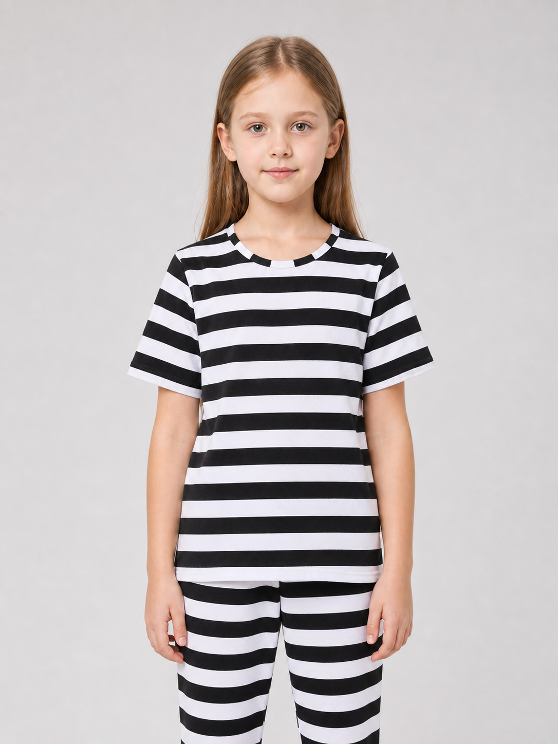 Children’s striped costume for themed outfits. The set is made in contrasting black and white: horizontal stripes appear on the short-sleeve top, pants, and headwear. This pattern immediately creates a recognizable dress-up look and helps a