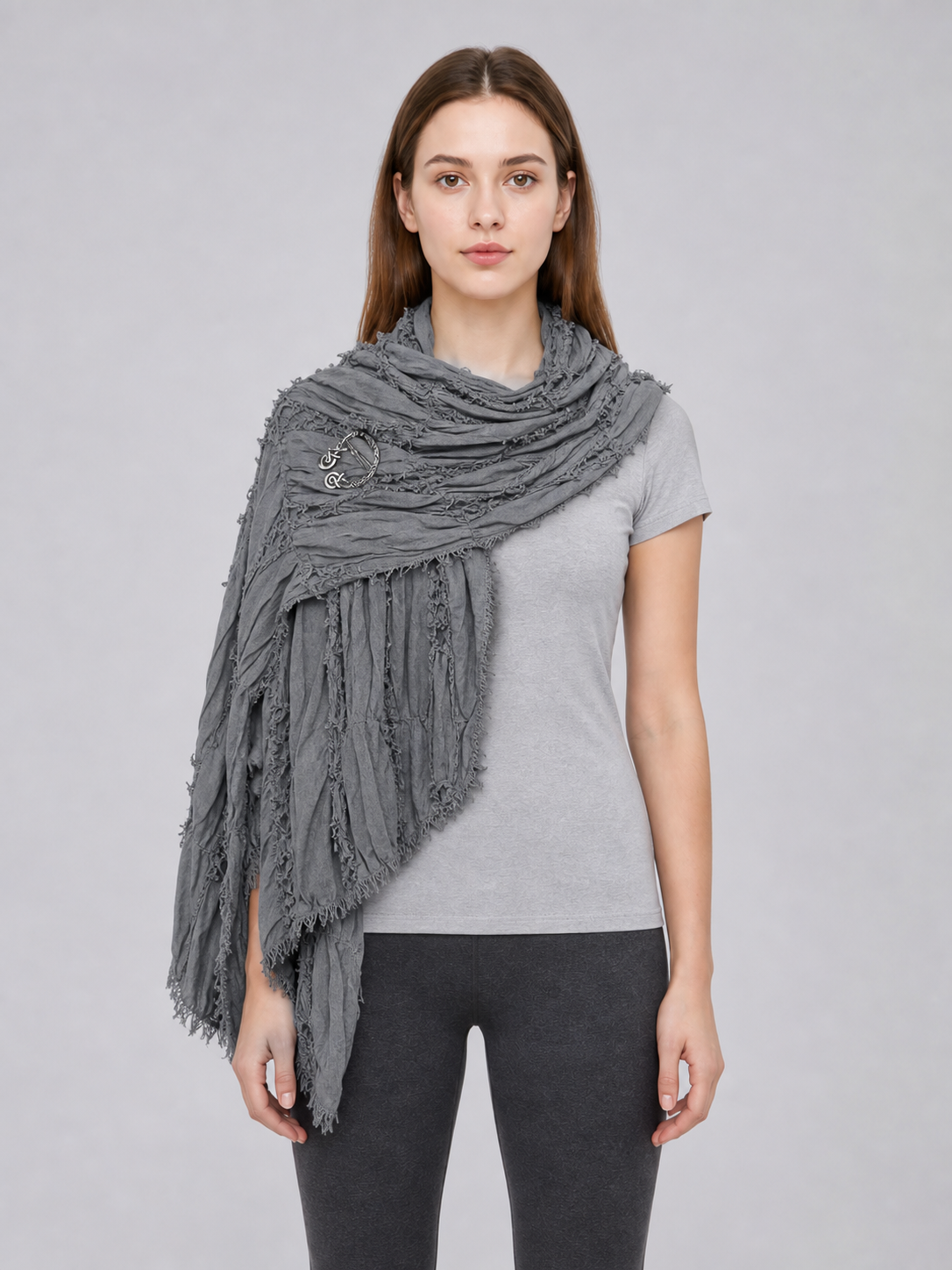 This large scarf-wrap is designed as a rectangular drape with a striking textured surface. The black-and-gray color palette is accented with lighter gray tones, giving the piece a distinctive look that pairs easily with different outfits. T