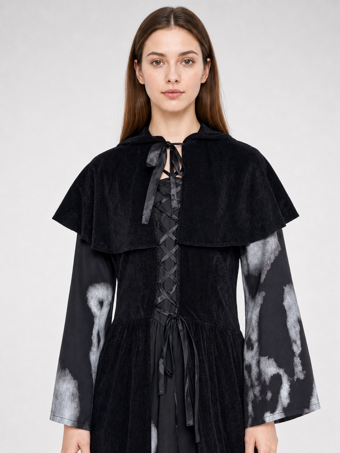 The black witch costume is designed as a long dress with a short shoulder cape. The design features a Halloween theme and is suitable for stage performances, festive events, and themed costumes. The front is decorated with crisscross lacing
